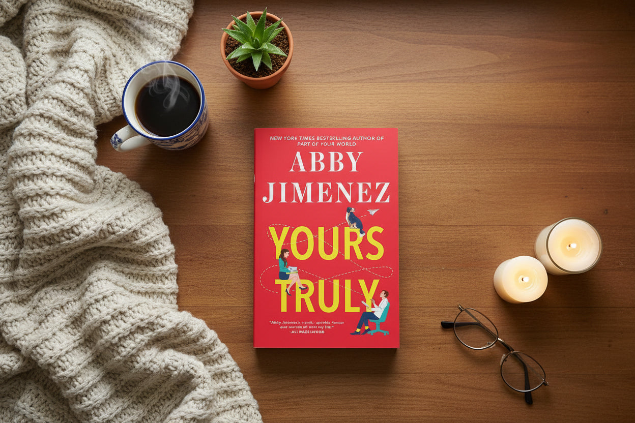 Book cover of 'Yours Truly' by Abby Jimenez with a red background and illustration of two people sitting apart.